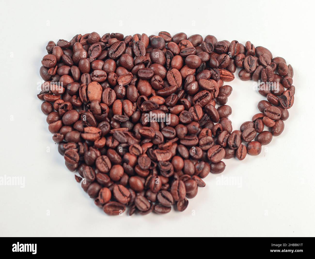 Tasse in Form von Kaffeebohnen auf weißem Hintergrund Stockfoto