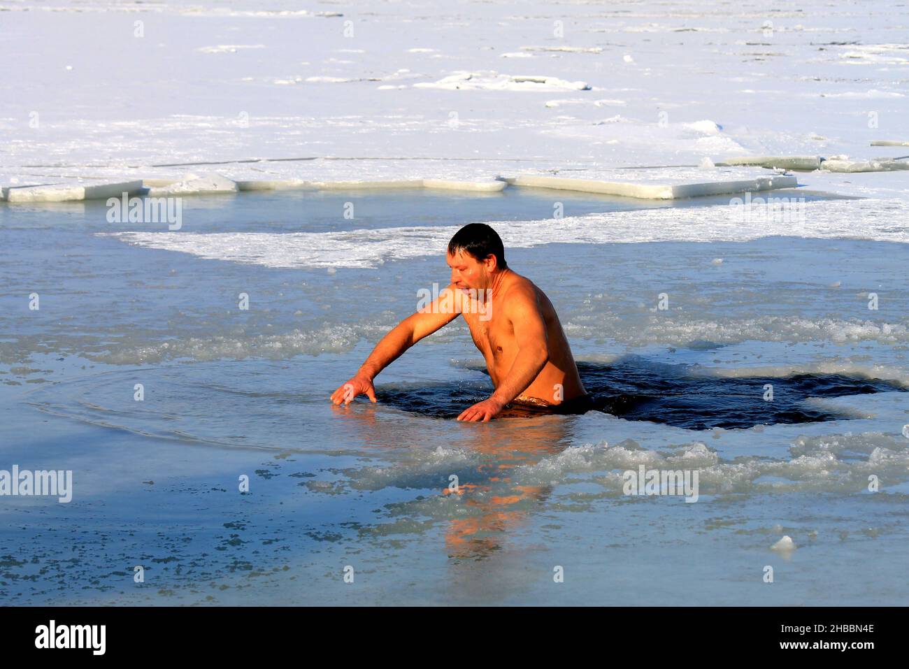 Winterschwimmen, härtend. Während des orthodoxen Feiertages von Epiphanie schwimmen Männer in einem mit Eis bedeckten Fluss. Wintersport, Dnipro, Ukraine, Dnepr, 2020 Stockfoto