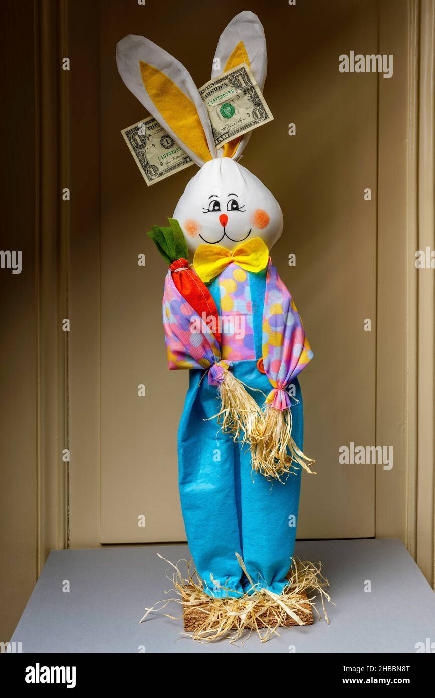 Gefülltes glückliches Kaninchen mit 1 einer US-Dollar-Banknote zwischen den Ohren, Stockfoto