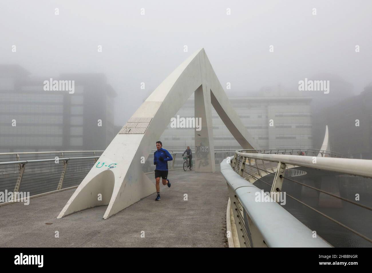 Glasgow, Großbritannien. 18th Dez 2021. Am frühen Morgen wurden Pendler von einem frostigen Nebel verwöhnt, der eine surreale Landschaft über dem Fluss Clyde und seinen Brücken, insbesondere der Tradeston Bridge (auch bekannt als die Squinty Bridge) und der Portland Suspension Bridge, schuf. Kredit: Findlay/Alamy Live Nachrichten Stockfoto