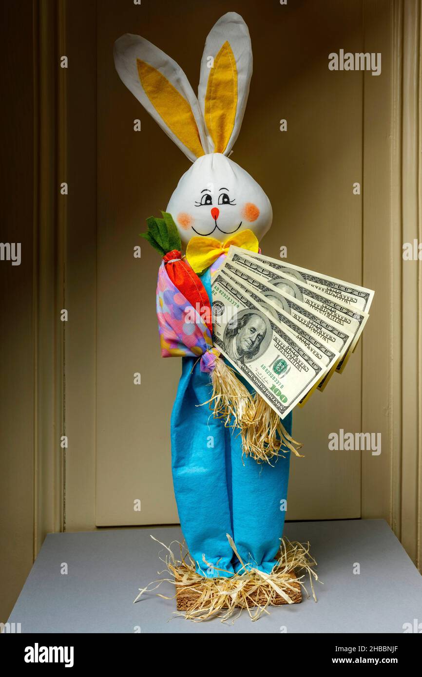 Gefülltes glückliches Kaninchen mit einem Fächer von hundert US-Dollar-Banknoten, Stockfoto