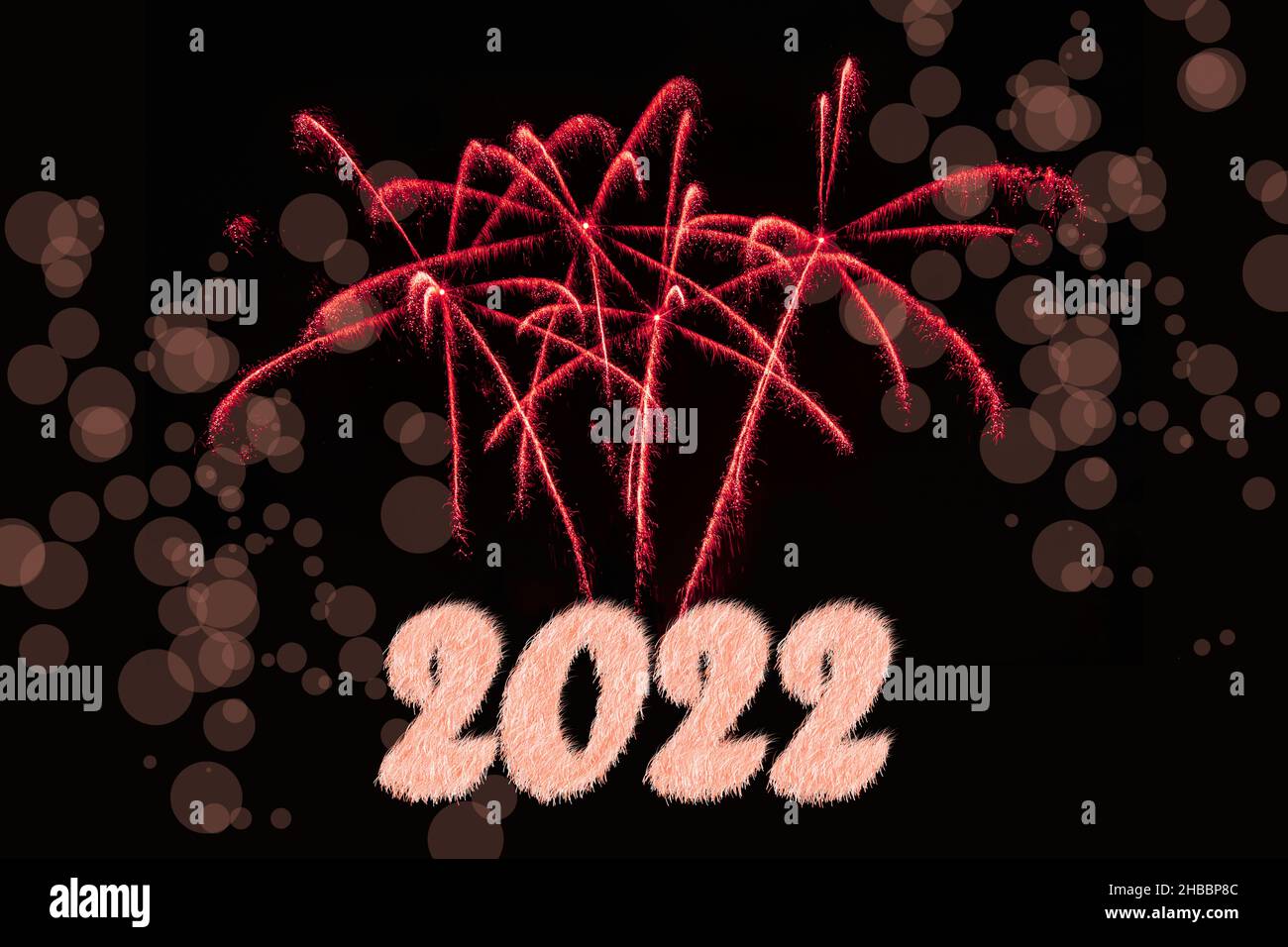 Frohes Neues Jahr 2022. Funkelnd brennende Zahlen Jahr 2022 mit Feuerwerk und Bokeh auf schwarzem Hintergrund. Stockfoto
