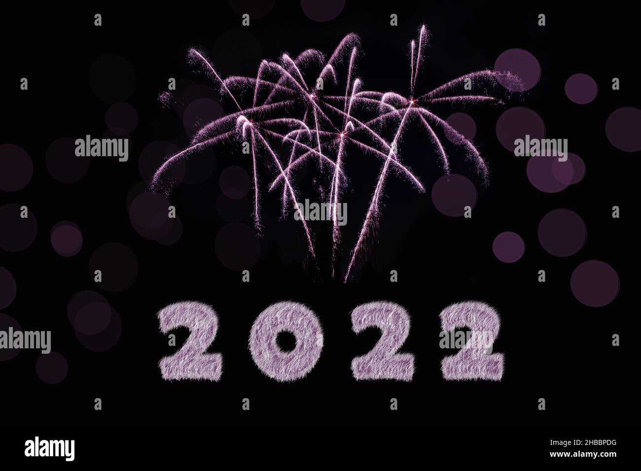Frohes Neues Jahr 2022. Funkelnd brennende Zahlen Jahr 2022 mit Feuerwerk und Bokeh auf schwarzem Hintergrund. Stockfoto