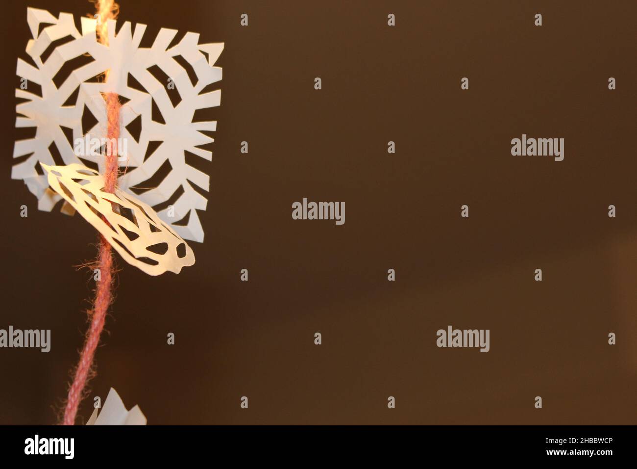 Schneeflocke aus Papier vor dunklem Hintergrund. Stockfoto