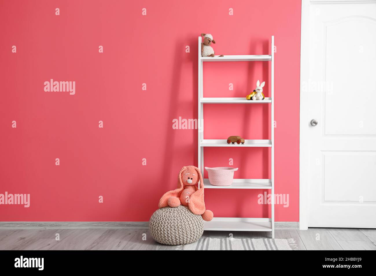 Regal mit Spielzeug in der Nähe der Farbwand im Zimmer Stockfotografie -  Alamy