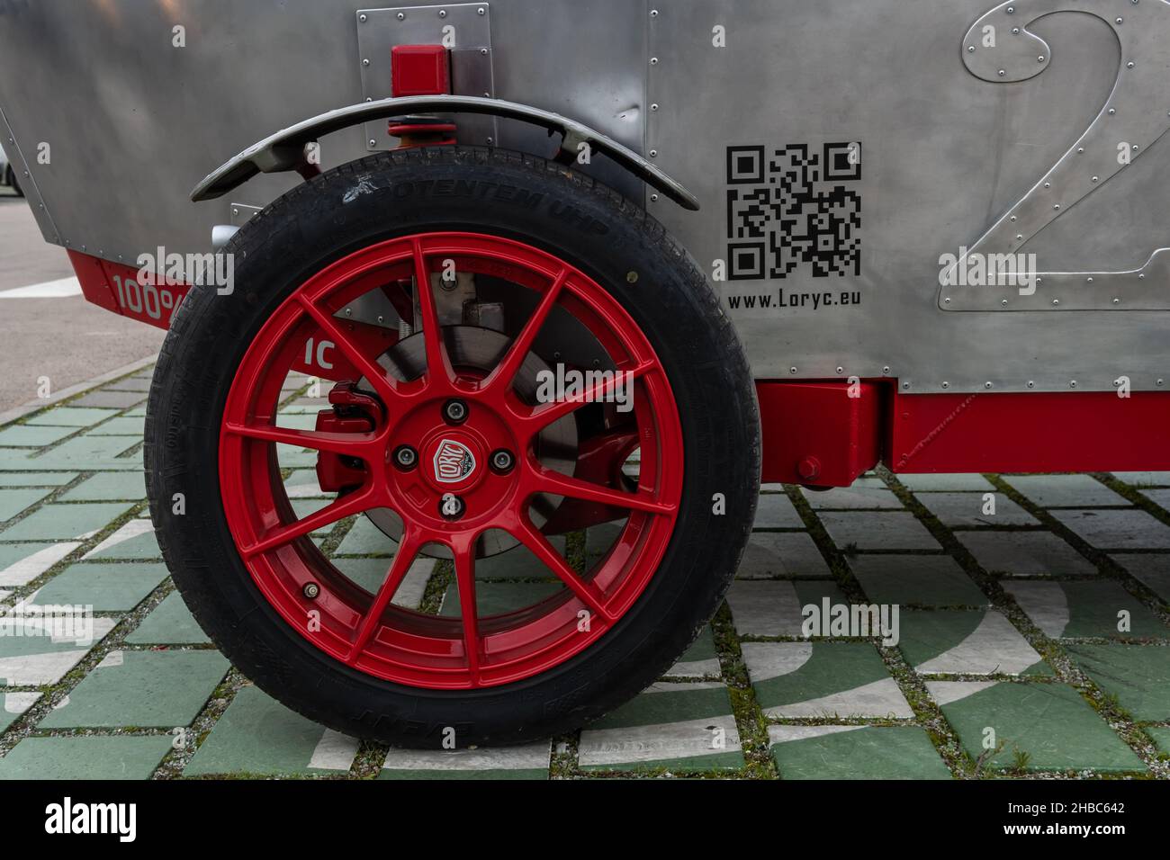 Campos, Spanien, dezember 11 2021: Lorycs modernes Elektroauto im Design von 1920s an einer elektrischen Ladestelle auf dem Parkplatz eines Lidl-Kettensupermar Stockfoto