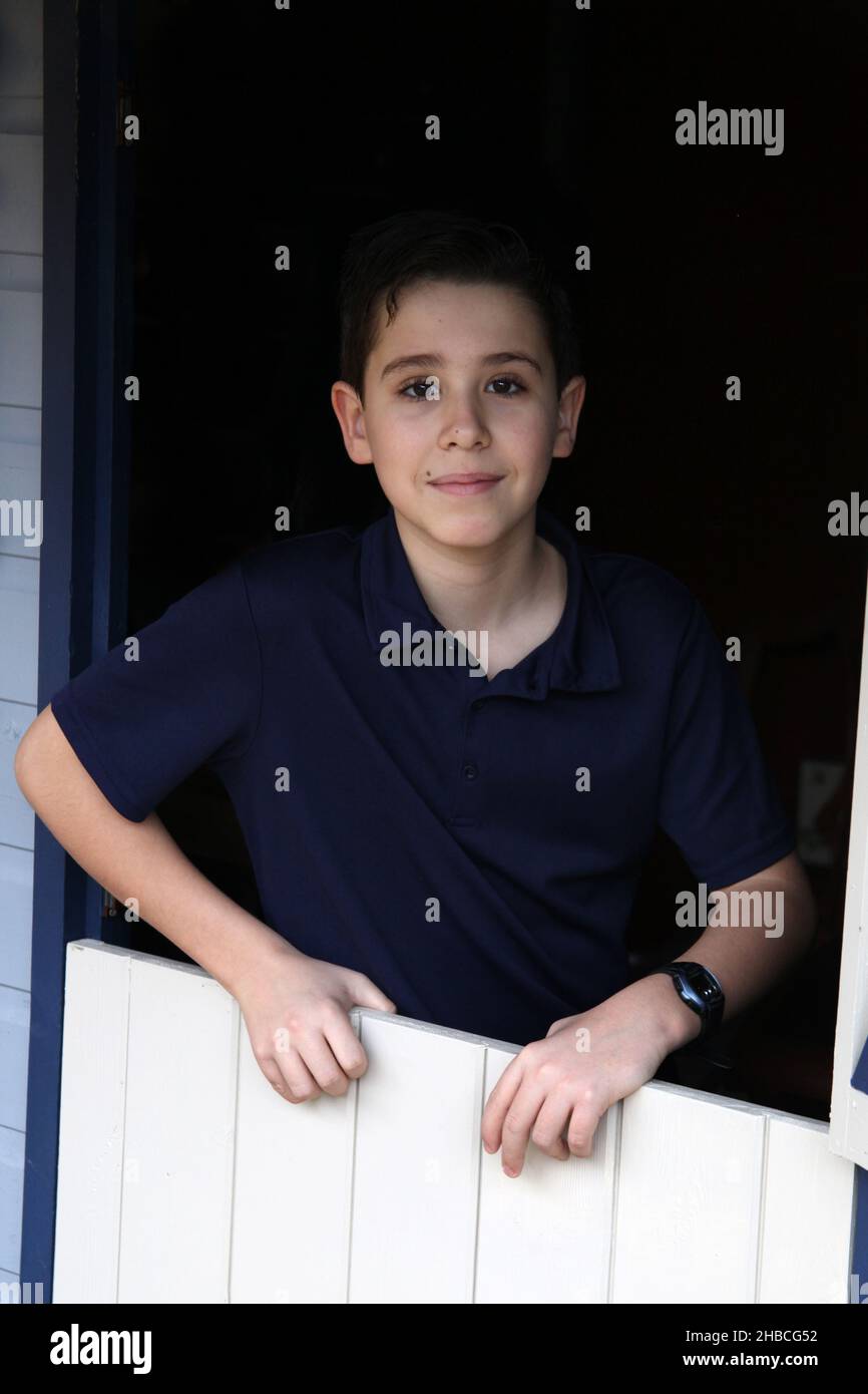Ein Porträt eines 12-jährigen Jungen, der von Umgebungslicht beleuchtet wird Stockfoto