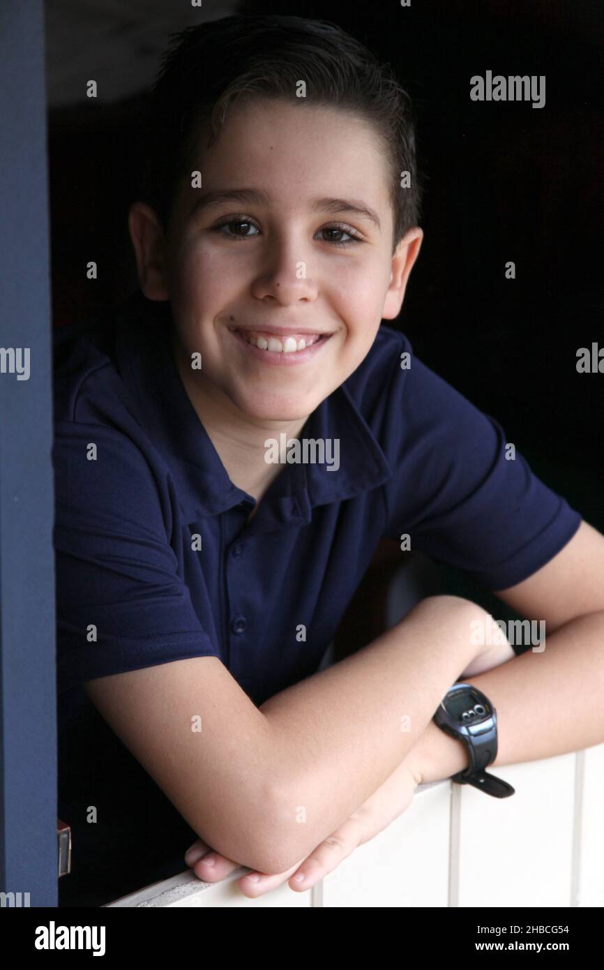 Ein Porträt eines 12-jährigen Jungen, der von Umgebungslicht beleuchtet wird Stockfoto