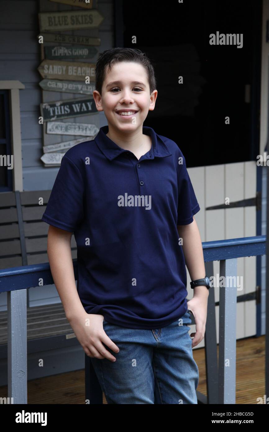 Ein Porträt eines 12-jährigen Jungen, der von Umgebungslicht durch ein Nebengebäude beleuchtet wird Stockfoto
