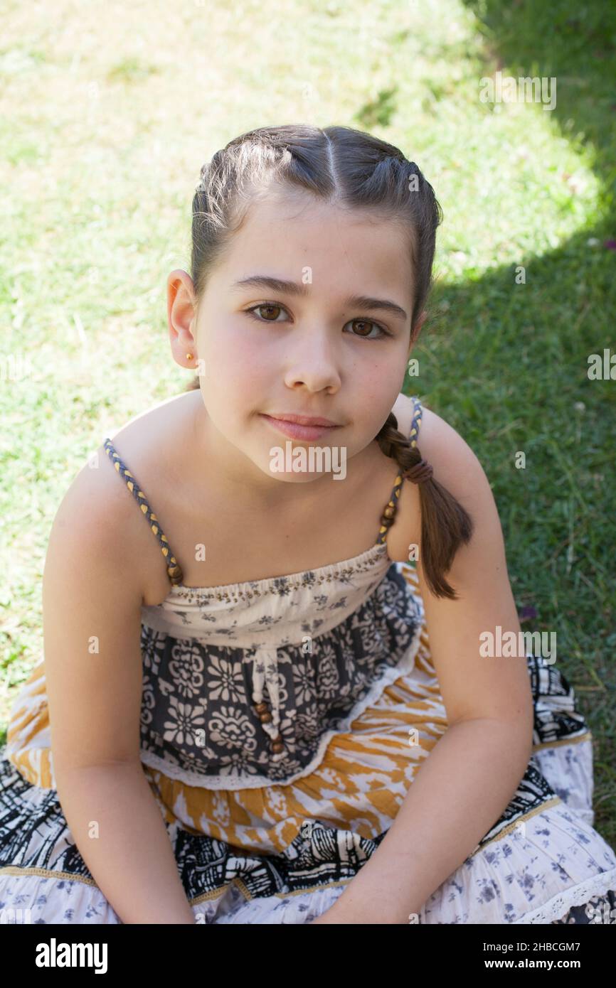 Ein Porträt eines 8-jährigen Mädchens in der Sonne an einem Sommertag Stockfoto