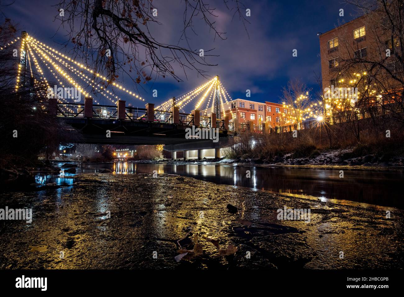 Die Washington Avenue Bridge wird von Weihnachtslichtern über Clear Creek in Golden, Colorado, USA, beleuchtet Stockfoto