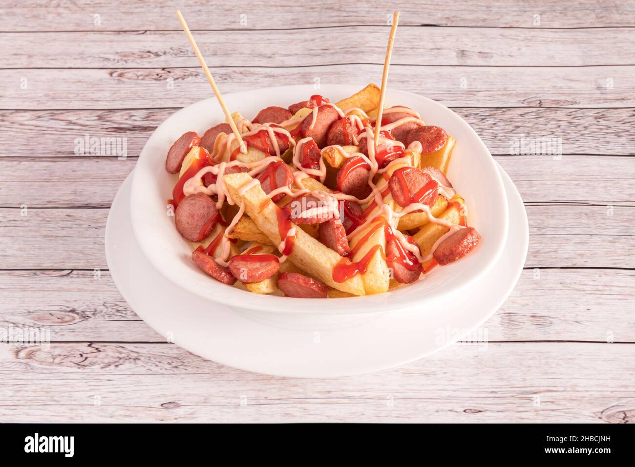 La salchipapa o salchipapas es una comida rápida que consistente en rodajas Fritas de salchicha y Papas Fritas, consumida como comida callejera en Hispan Stockfoto