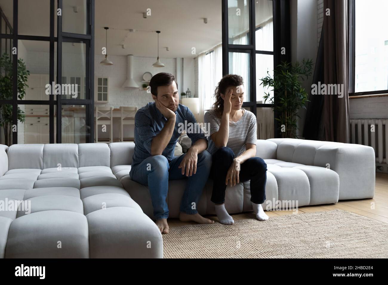 Müde junge Paar auf der Couch sitzen, denken über Beziehungsprobleme Stockfoto