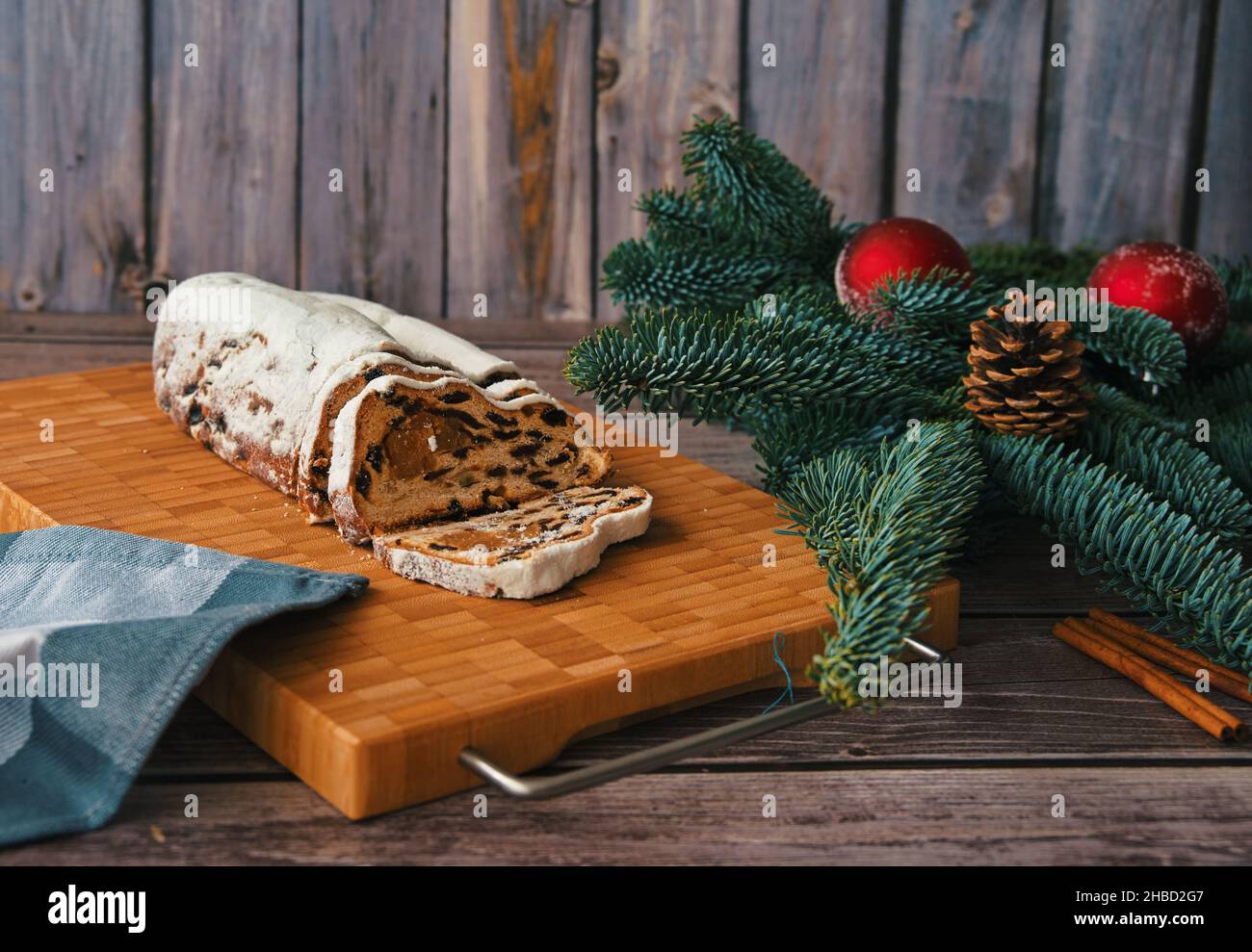 Weihnachtsbrot auf Schneidebrett mit Ast und Weihnachtsschmuck verziert Stockfoto