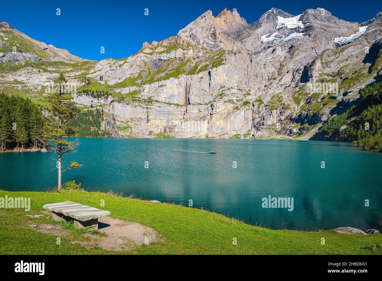 Toller Ruheplatz mit Holzbank und malerischer Aussicht. Herrlicher See und Berge mit Gletschern, Oeschinensee, Berner Oberland, Schweiz Stockfoto