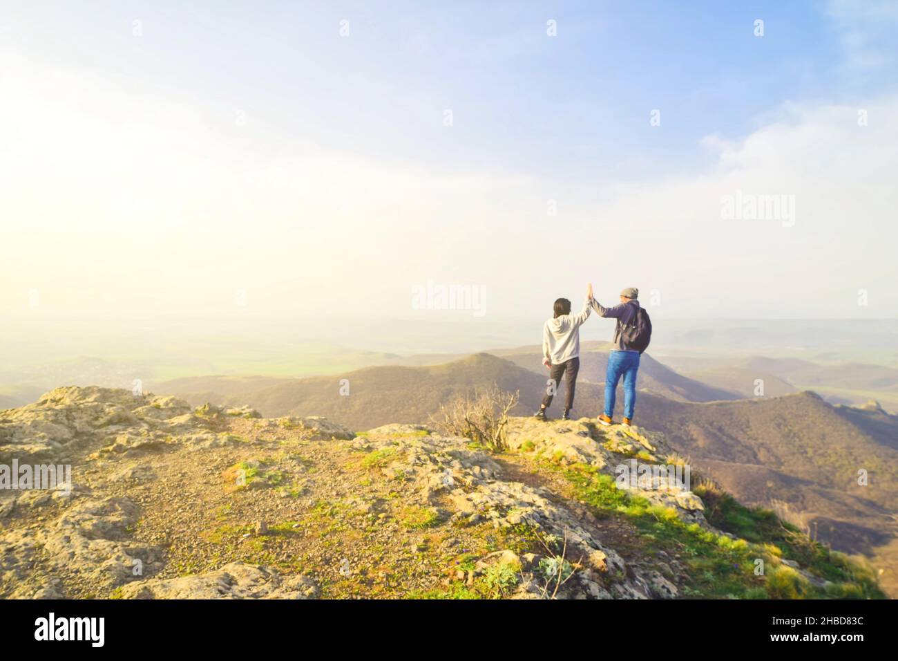 Kaukasisches Paar genießen Panorama zusammen mit den Händen klatschen draußen.Erfolg, Freiheit und glückliche Reisen Konzept. Stockfoto