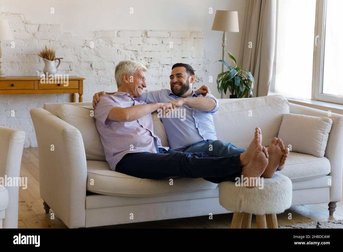 Glücklich bindenden Senior Mann mit erwachsener Sohn Fäuste stoßen. Stockfoto