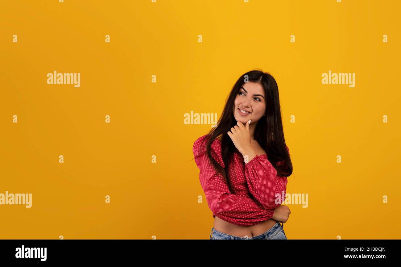 Porträt einer nachdenklichen armenischen Frau, die das Kinn berührt und den freien Raum betrachtet, wobei sie ein Interessantes Angebot in Betracht zieht Stockfoto