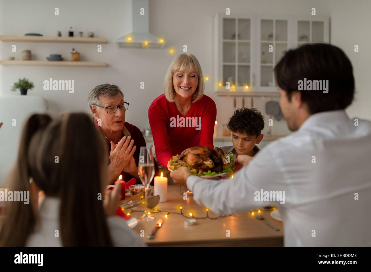 Ältere Frau serviert traditionelle Weihnachts-türkei für große Multi-Generation-Familie, feiert Weihnachten Urlaub zu Hause Stockfoto