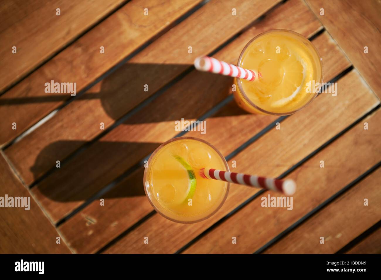 Zwei erfrischende kalte Getränke. Gläser Cocktails mit Eis und frischem Obst auf einem Holztisch. Stockfoto