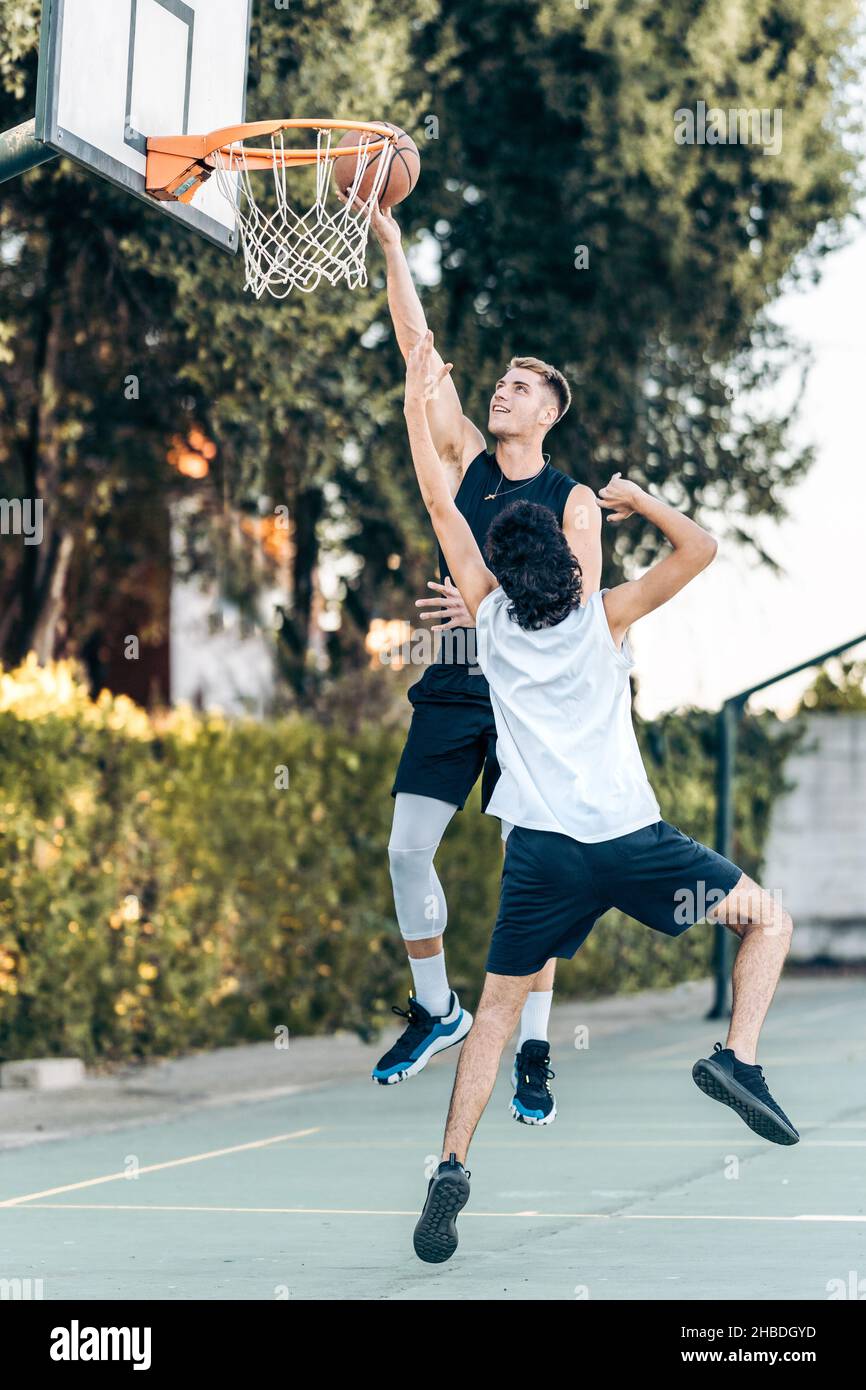 Ein männlicher Basketballspieler erzielte in einem Spiel zwischen Freunden einen Treffer Stockfoto