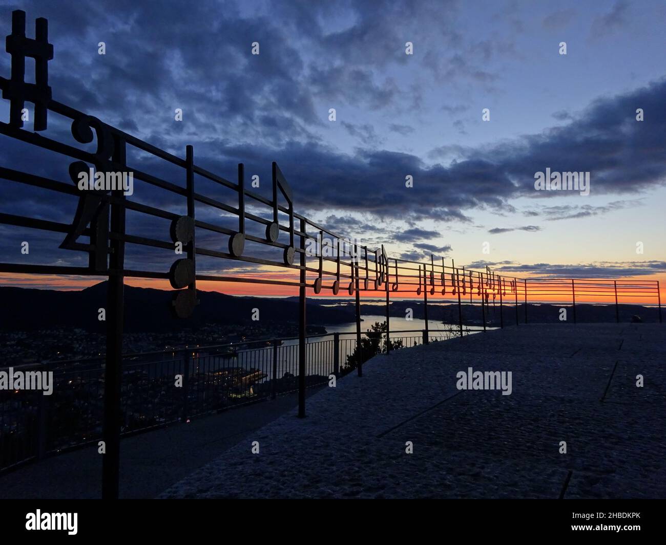 Eine Aussichtsplattform mit Musiknoten auf Metallgeländern bei Sonnenuntergang Stockfoto