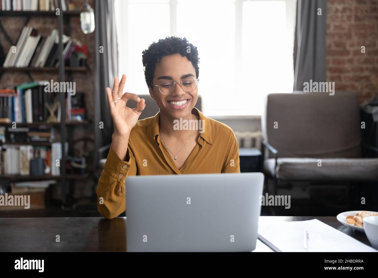 Glückliche junge afroamerikanische Frau, die per Videoanruf kommuniziert. Stockfoto