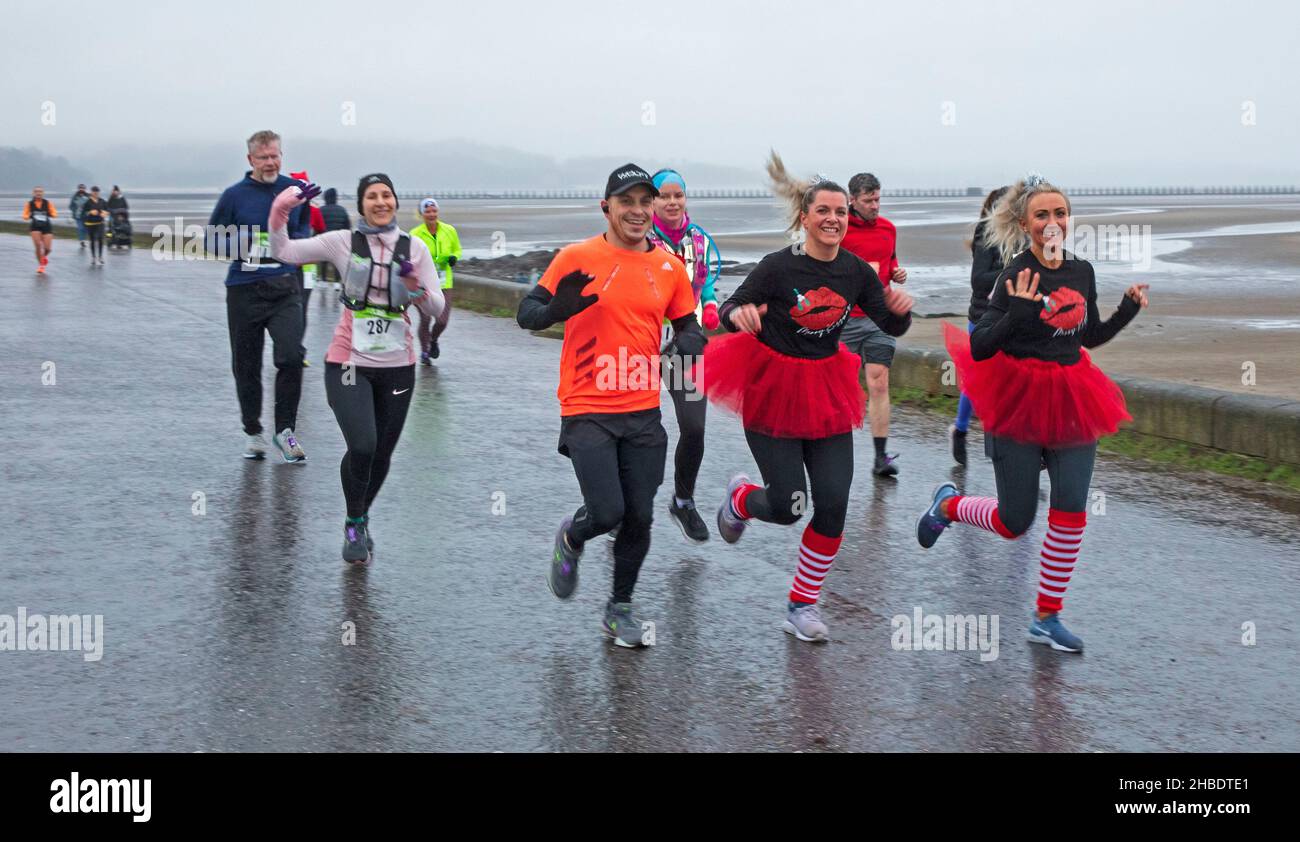 Silverknowes Promenade, Edinburgh, Santa Half Marathon neben 7k und 14k, Schottland, Großbritannien. 19th. Dezember 2021. Ein sehr trister Tag mit konstantem Nieselregen und 4 Grad Celsius für den „Blast Running SANTA DASH“ hielt diese glücklichen Seelen nicht davon ab, ihren Marathon-Wettkampf im Dezember zu genießen. Credit: Arch White Stockfoto Silverknowes Promenade, Edinburgh, Santa Half Marathon neben 7k und 14k, Schottland, Großbritannien. 19th. Dezember 2021. Ein sehr trister Tag mit konstantem Nieselregen und 4 Grad Celsius für den „Blast Running SANTA DASH“ hielt diese glücklichen Seelen nicht davon ab, ihren Marathon-Wettkampf im Dezember zu genießen. Credit: Arch White Stockfoto