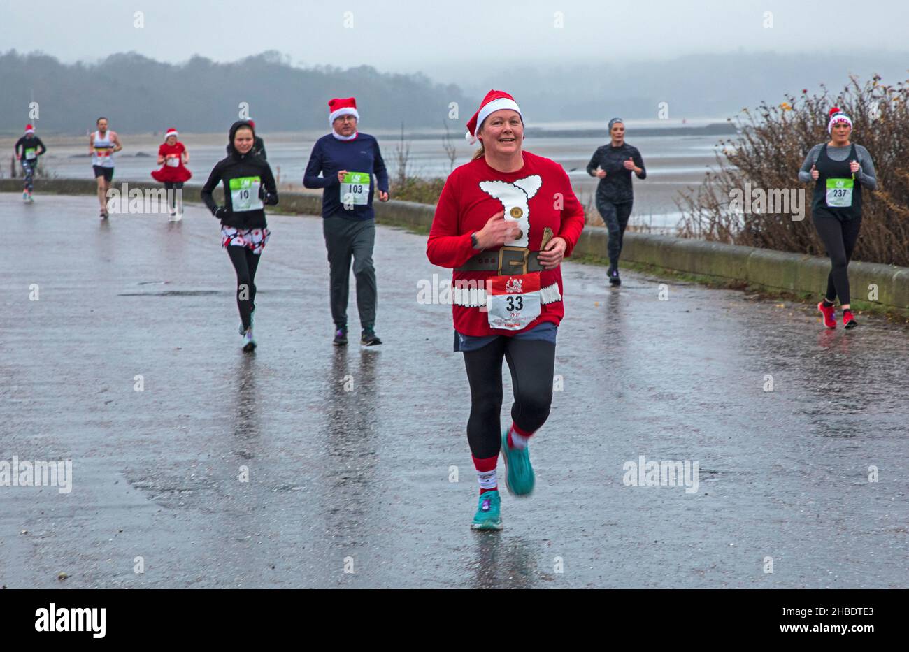 Silverknowes Promenade, Edinburgh, Santa Half Marathon neben 7k und 14k, Schottland, Großbritannien. 19th. Dezember 2021. Ein sehr trister Tag mit konstantem Nieselregen und 4 Grad Celsius für den „Blast Running SANTA DASH“ hielt diese glücklichen Seelen nicht davon ab, ihren Marathon-Wettkampf im Dezember zu genießen. Credit: Arch White/ Stockfoto Silverknowes Promenade, Edinburgh, Santa Half Marathon neben 7k und 14k, Schottland, Großbritannien. 19th. Dezember 2021. Ein sehr trister Tag mit konstantem Nieselregen und 4 Grad Celsius für den „Blast Running SANTA DASH“ hielt diese glücklichen Seelen nicht davon ab, ihren Marathon-Wettkampf im Dezember zu genießen. Credit: Arch White/ Stockfoto