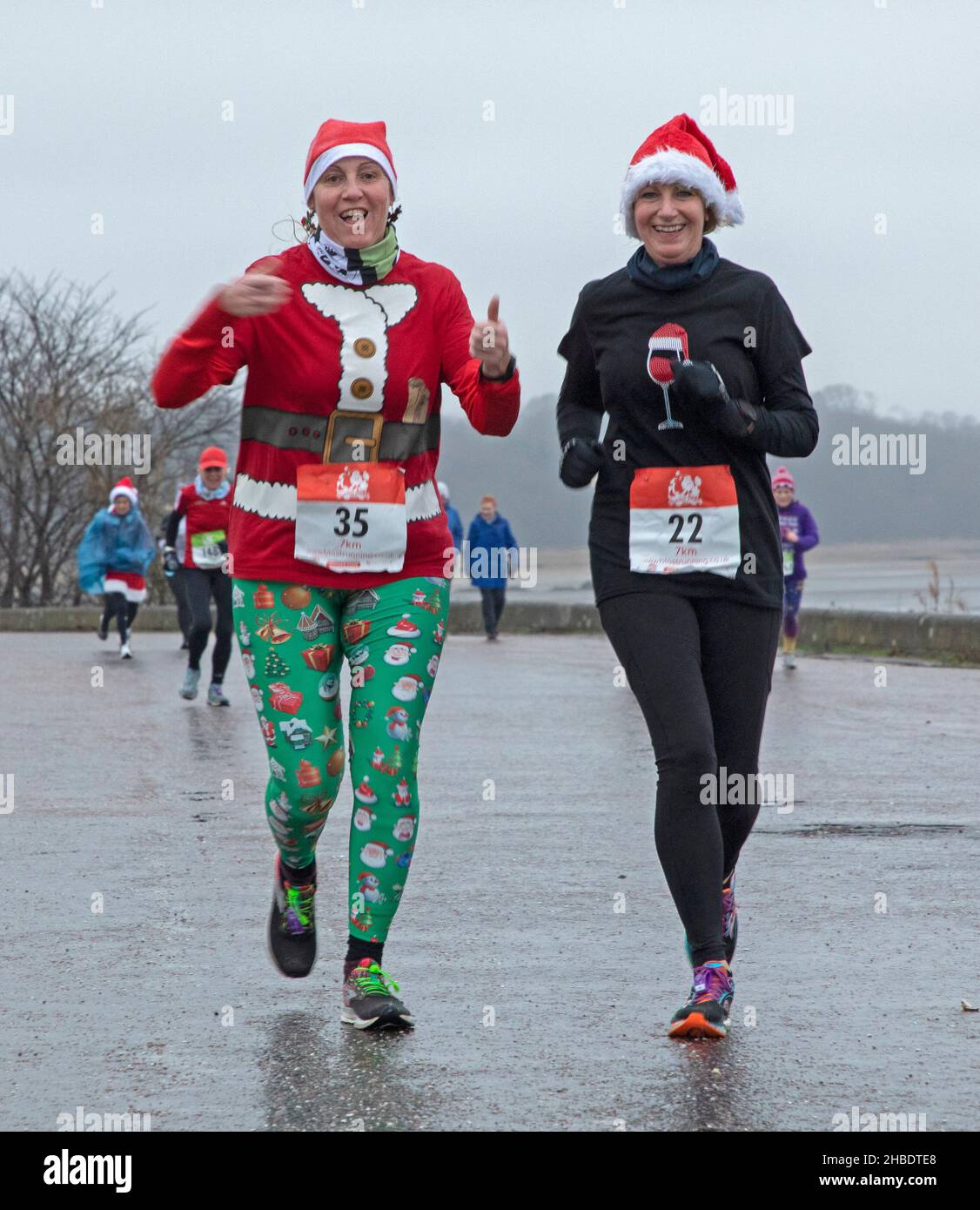 Silverknowes Promenade, Edinburgh, Santa Half Marathon neben 7k und 14k, Schottland, Großbritannien. 19th. Dezember 2021. Ein sehr trister Tag mit konstantem Nieselregen und 4 Grad Celsius für den „Blast Running SANTA DASH“ hielt diese glücklichen Seelen nicht davon ab, ihren Marathon-Wettkampf im Dezember zu genießen. Credit: Arch White/ Stockfoto