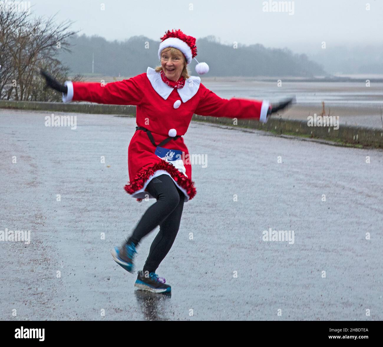 Silverknowes Promenade, Edinburgh, Santa Half Marathon neben 7k und 14k, Schottland, Großbritannien. 19th. Dezember 2021. Ein sehr trister Tag mit konstantem Nieselregen und 4 Grad Celsius für den „Blast Running SANTA DASH“ hielt diese glücklichen Seelen nicht davon ab, ihren Marathon-Wettkampf im Dezember zu genießen. Pictiured: Shona genießt ihre Übung. Credit: Arch White Stockfoto Silverknowes Promenade, Edinburgh, Santa Half Marathon neben 7k und 14k, Schottland, Großbritannien. 19th. Dezember 2021. Ein sehr trister Tag mit konstantem Nieselregen und 4 Grad Celsius für den „Blast Running SANTA DASH“ hielt diese glücklichen Seelen nicht davon ab, ihren Marathon-Wettkampf im Dezember zu genießen. Pictiured: Shona genießt ihre Übung. Credit: Arch White Stockfoto