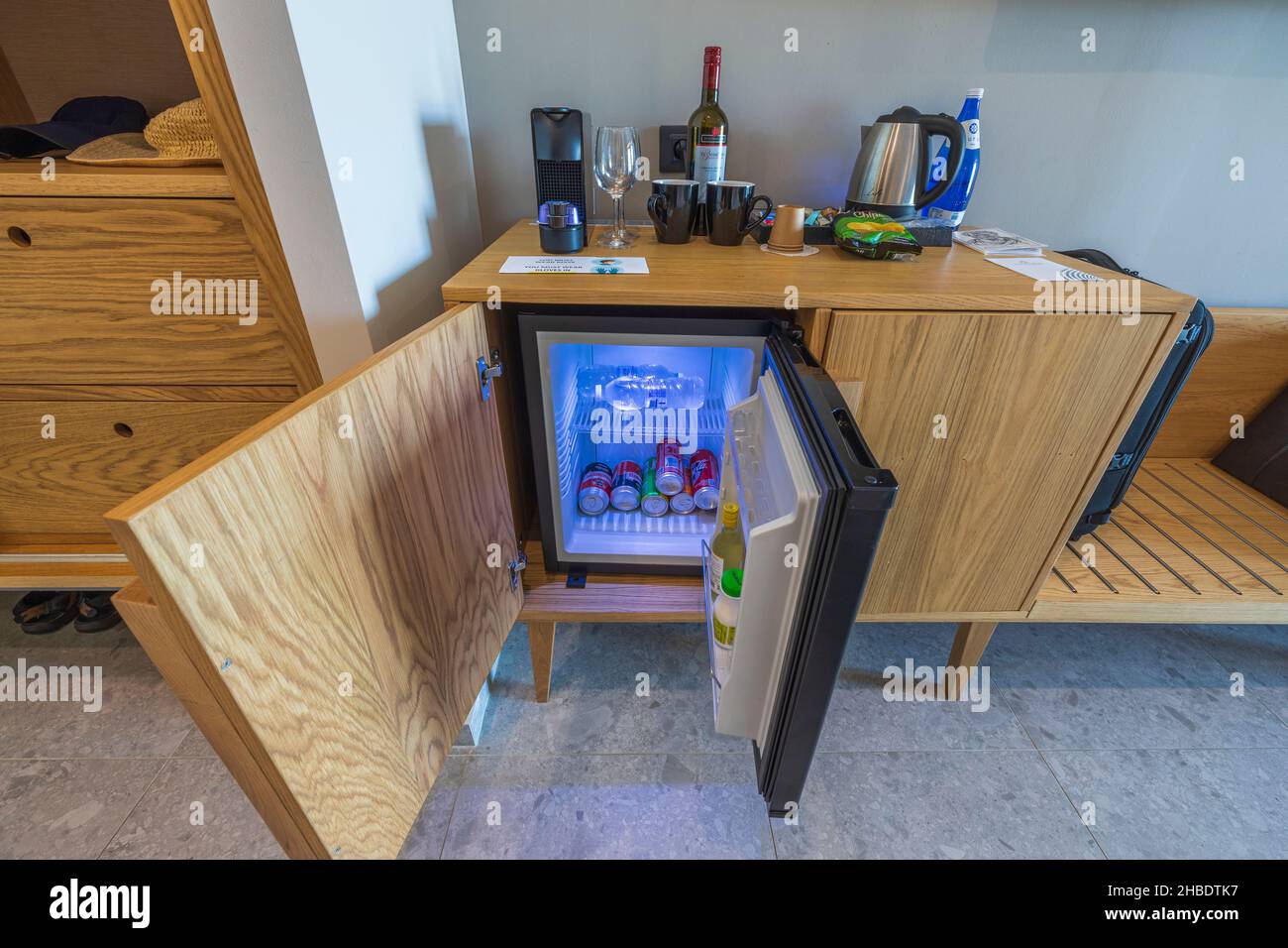 Nahaufnahme der offenen Minibar, Kapsel-Kaffeemaschine und Kaffeesorten im Hotelzimmer. Griechenland. Nea Potidaea. Stockfoto