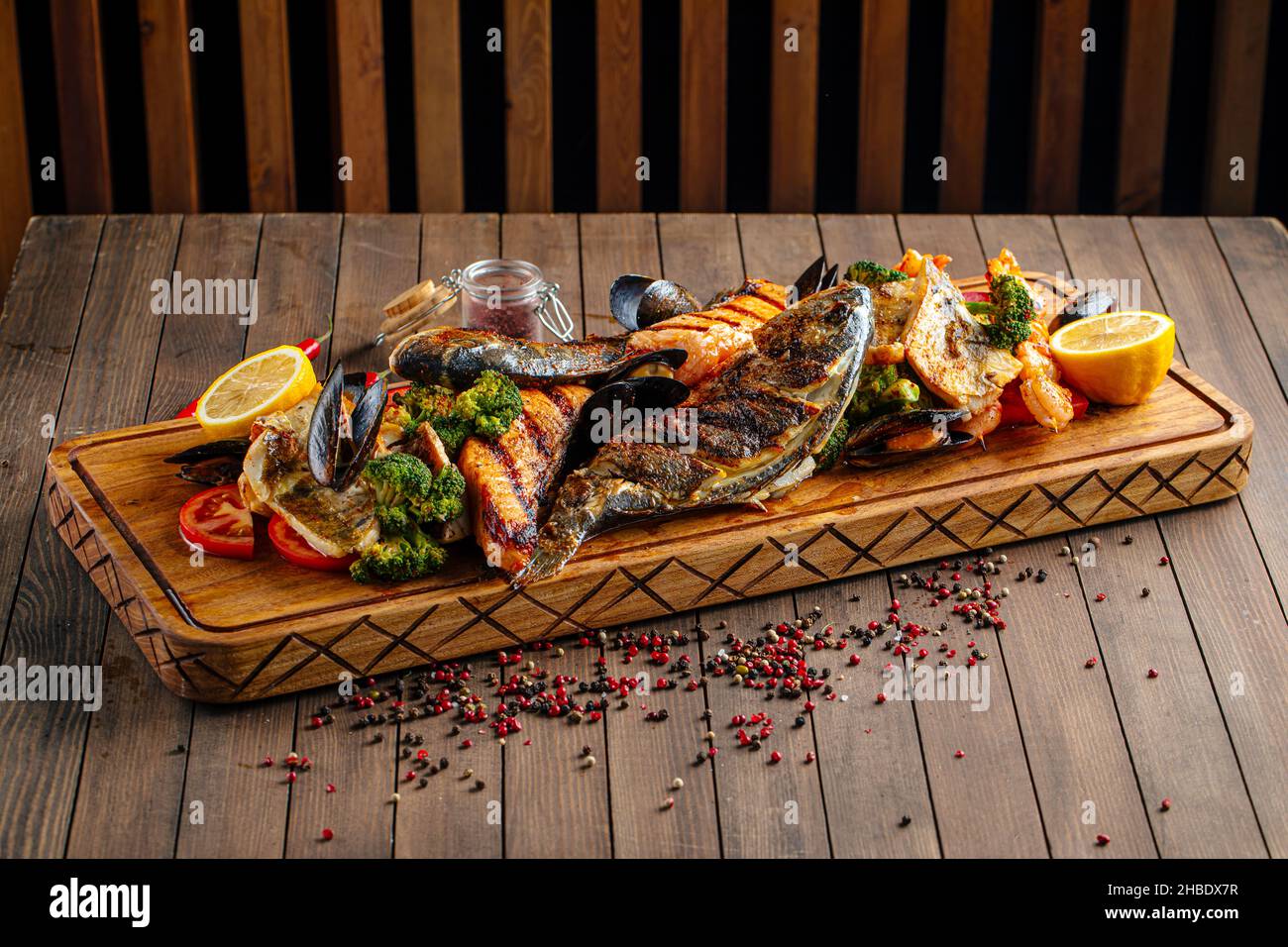 Verschiedene gegrillte Fische auf einem Holzbrett Stockfoto