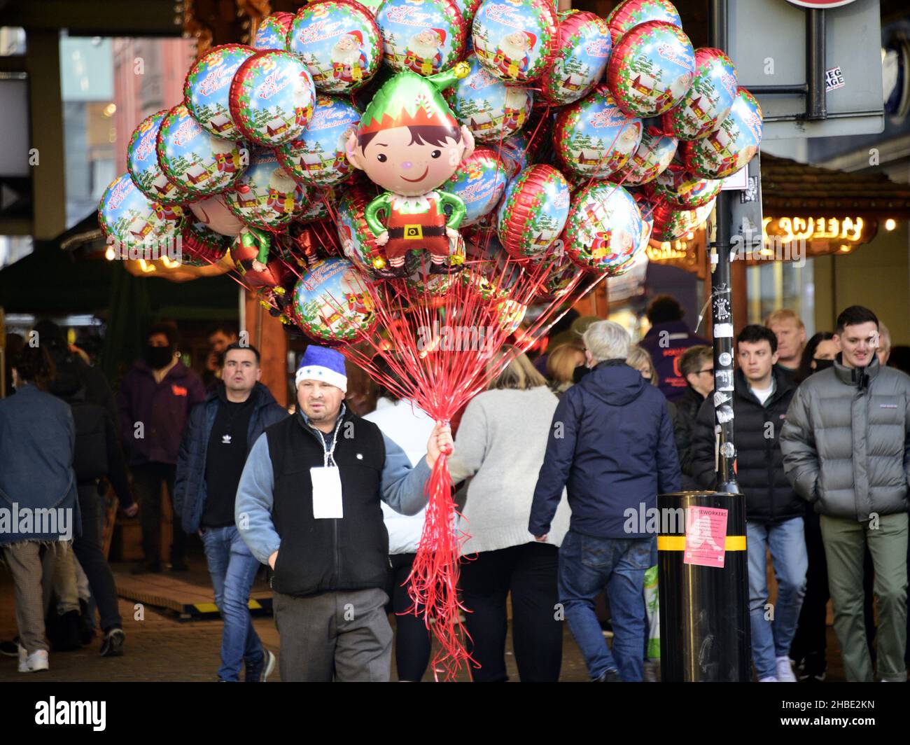 Manchester, Großbritannien, 19th. Dezember 2021. Mann verkauft Ballons. Stadtzentrum Manchester, England, Großbritannien, war am letzten Sonntag vor Weihnachten voller Weihnachtseinkäufer. Stockfoto