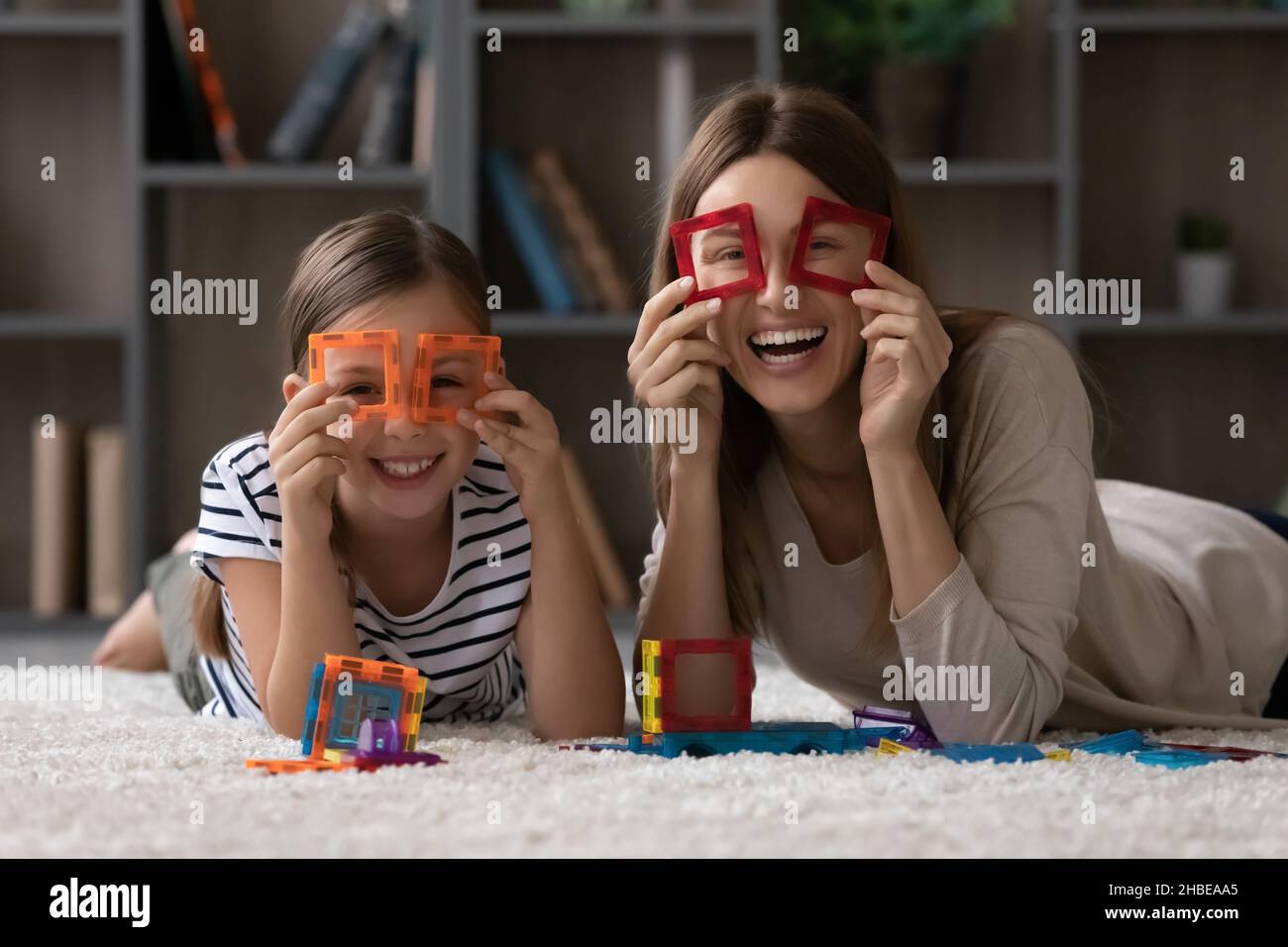 Junge Mutter und Schulmädchen Tochter Herstellung Fernglas von Magnet Konstruktor Stockfoto