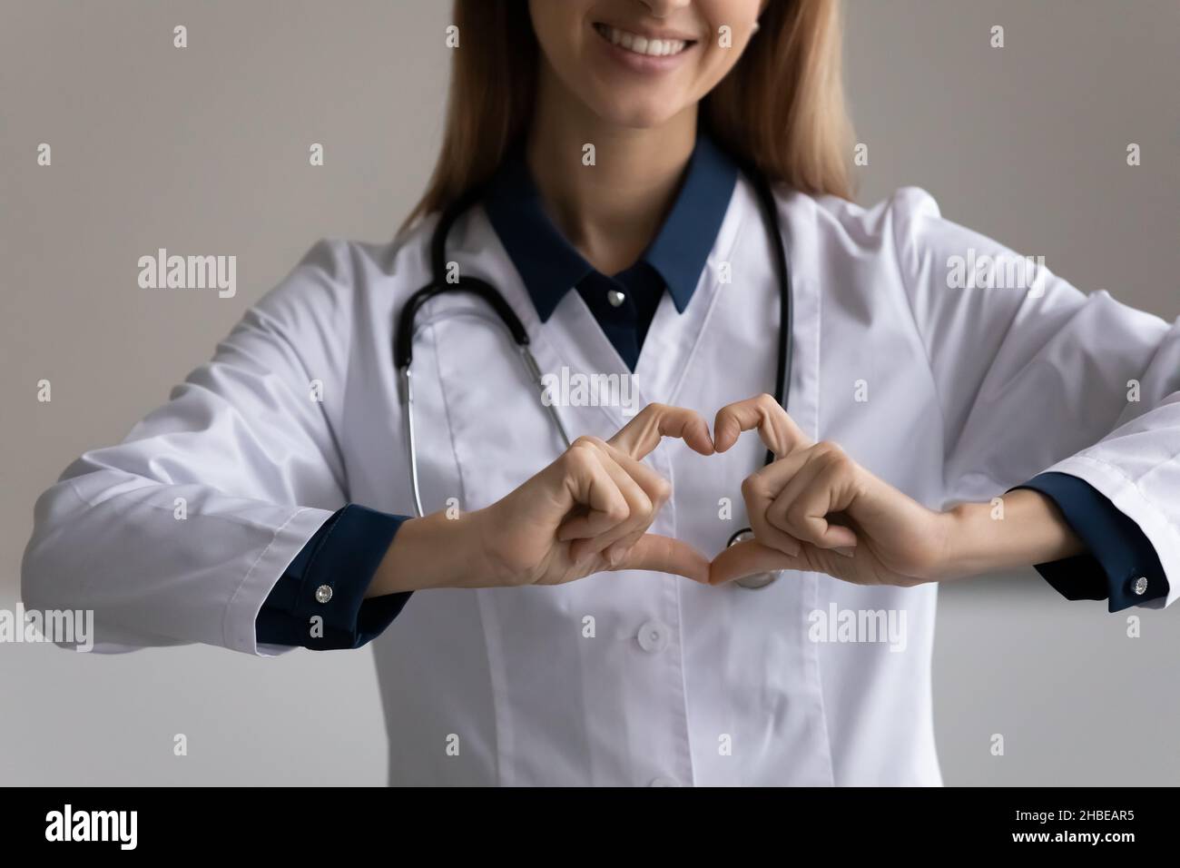 Nahaufnahme einer jungen Ärztin, die ein Herz aus Fingern macht Stockfoto