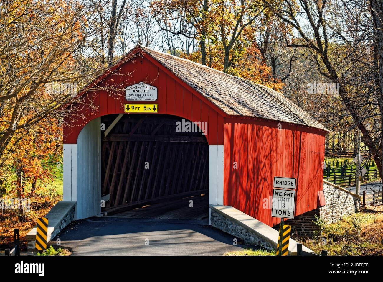 Landschaftlich schöner Herbstblick auf die Knechts Covered Bridge über den Crook Creek, Bucks County, Pennsylvania, USA Stockfoto