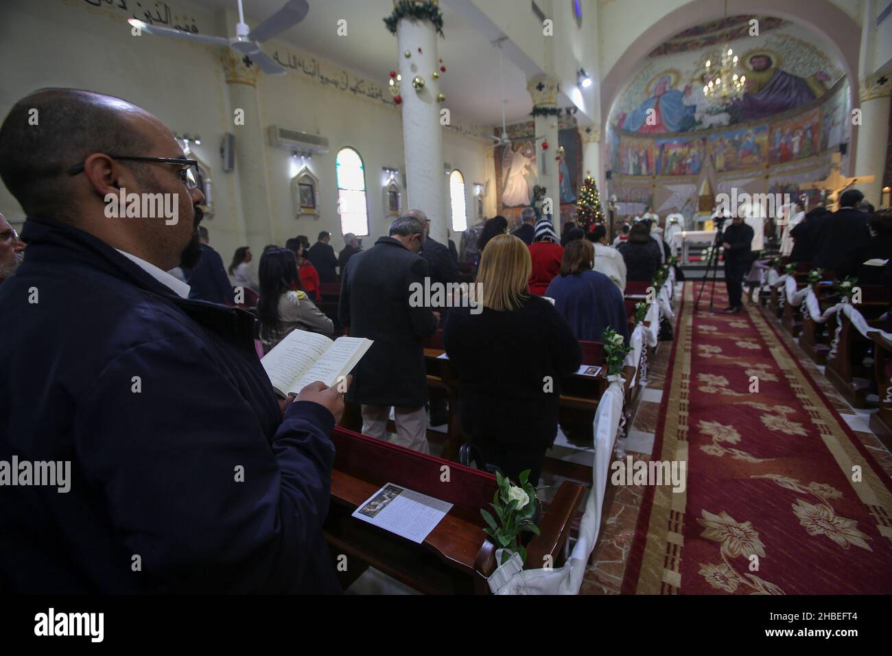 Palästinensische christliche Gläubiger in der römisch-katholischen Kirche der Heiligen Familie zu Beginn der Weihnachtsfeiertage in Gaza-Stadt am 19. Dezember 2021. Stockfoto