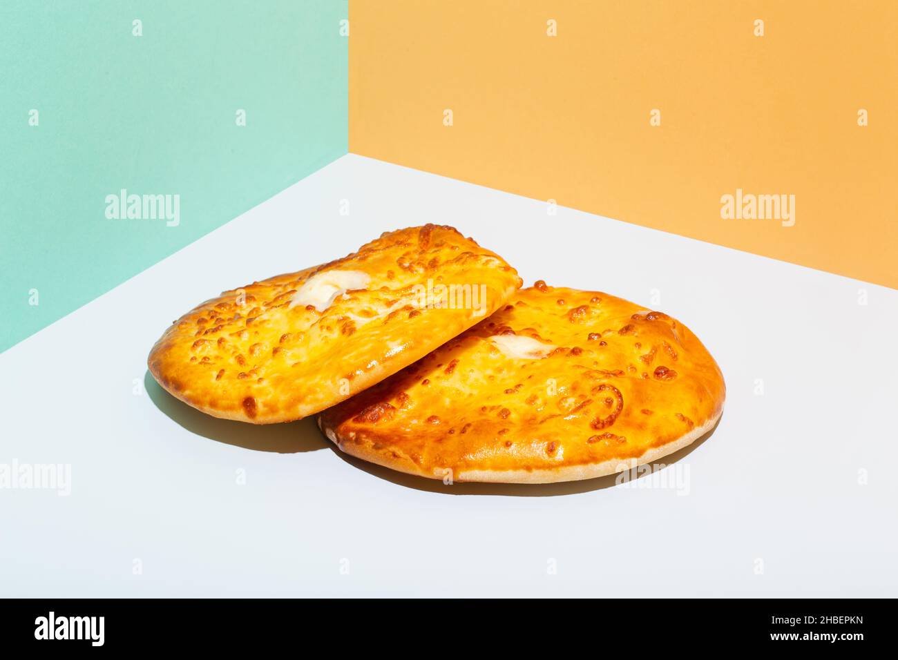 Usbekische Nationalkost Tandyr Brot Lepeshka mit Käse auf blauem Hintergrund minimalistischer Stil Stockfoto