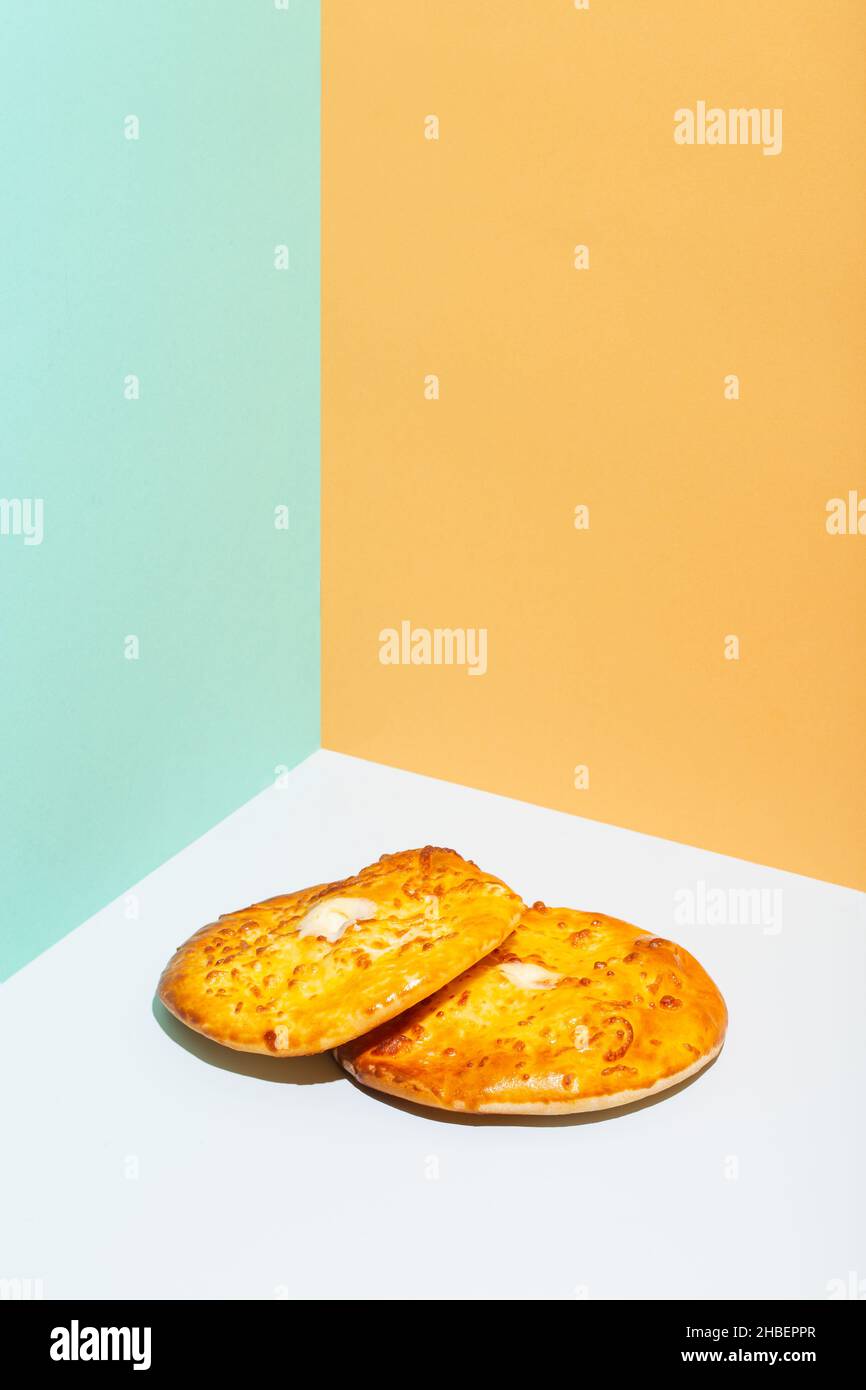 Usbekische Nationalkost Tandyr Brot Lepeshka mit Käse auf blauem Hintergrund minimalistischer Stil Stockfoto