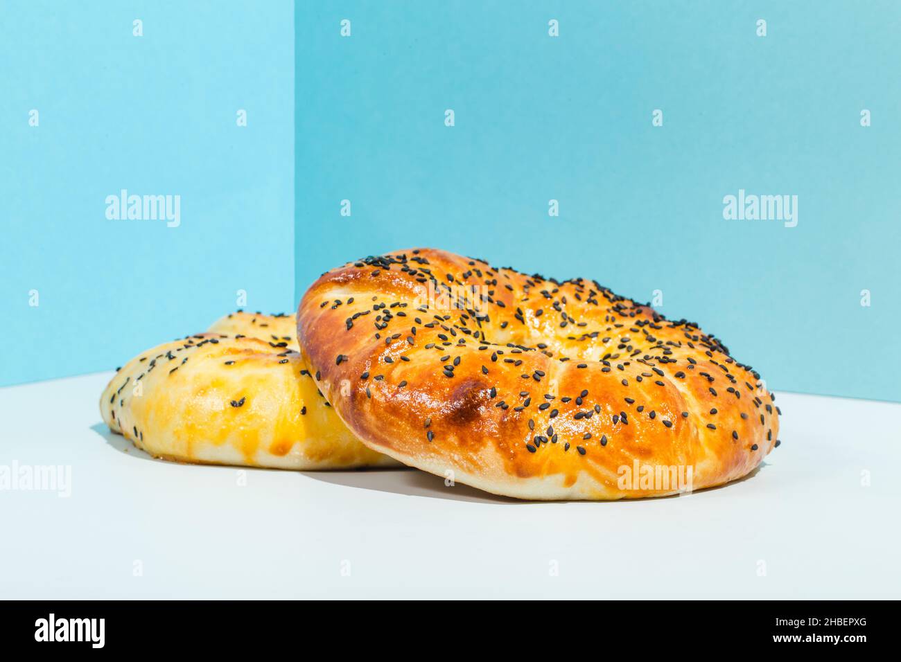 Usbekische Nationalkost Tandyr Brot Lepeshka mit Käse auf blauem Hintergrund minimalistischer Stil Stockfoto