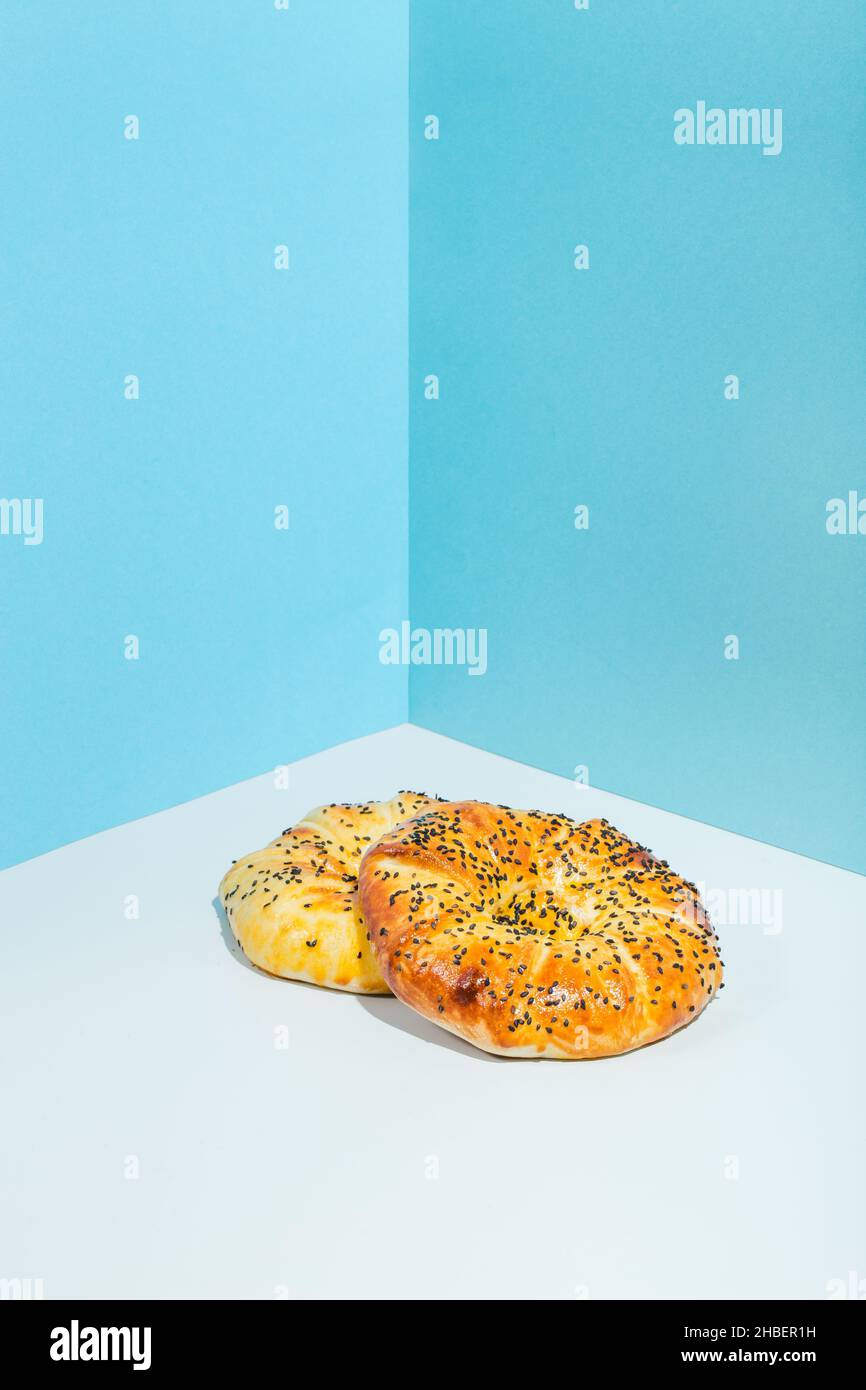 Usbekische Nationalkost Tandyr Brot Lepeshka mit Käse auf blauem Hintergrund minimalistischer Stil Stockfoto