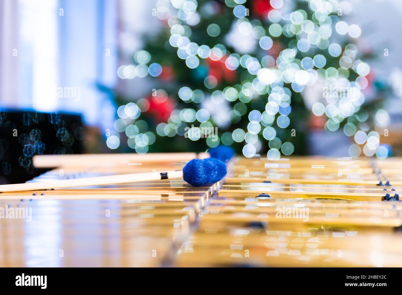 Vibraphon-Sticks liegen auf diesem Percussion-Instrument. Im Hintergrund verschwommene, unscharfe Lichter des Weihnachtsbaums. Stockfoto