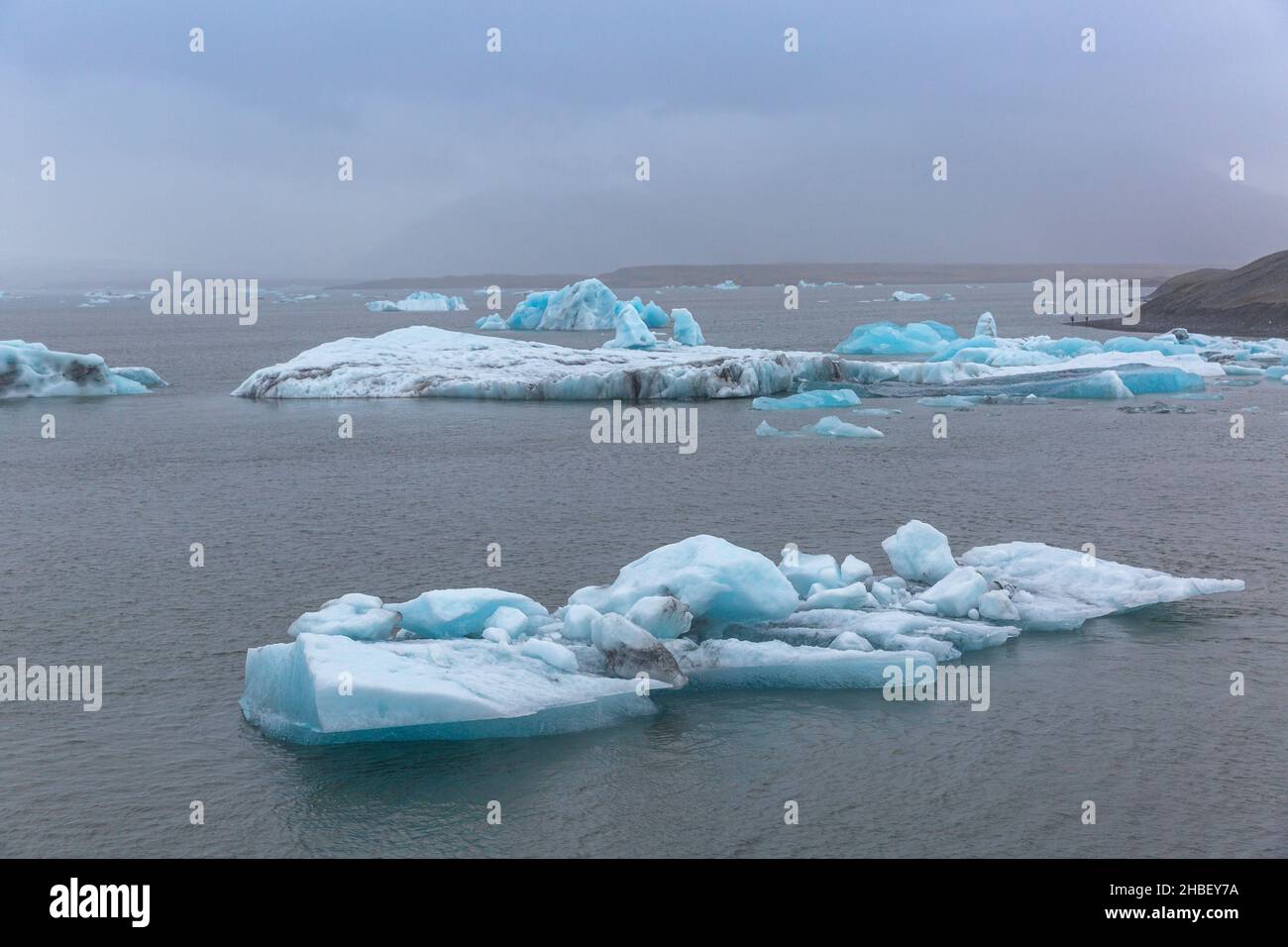 Jökulsárlón ist eine Gletscherlagune und grenzt an den Vatnajökull National Park im Südosten Islands. Sein stilles, blaues Wasser ist mit Eisbergen aus dem übersät Stockfoto