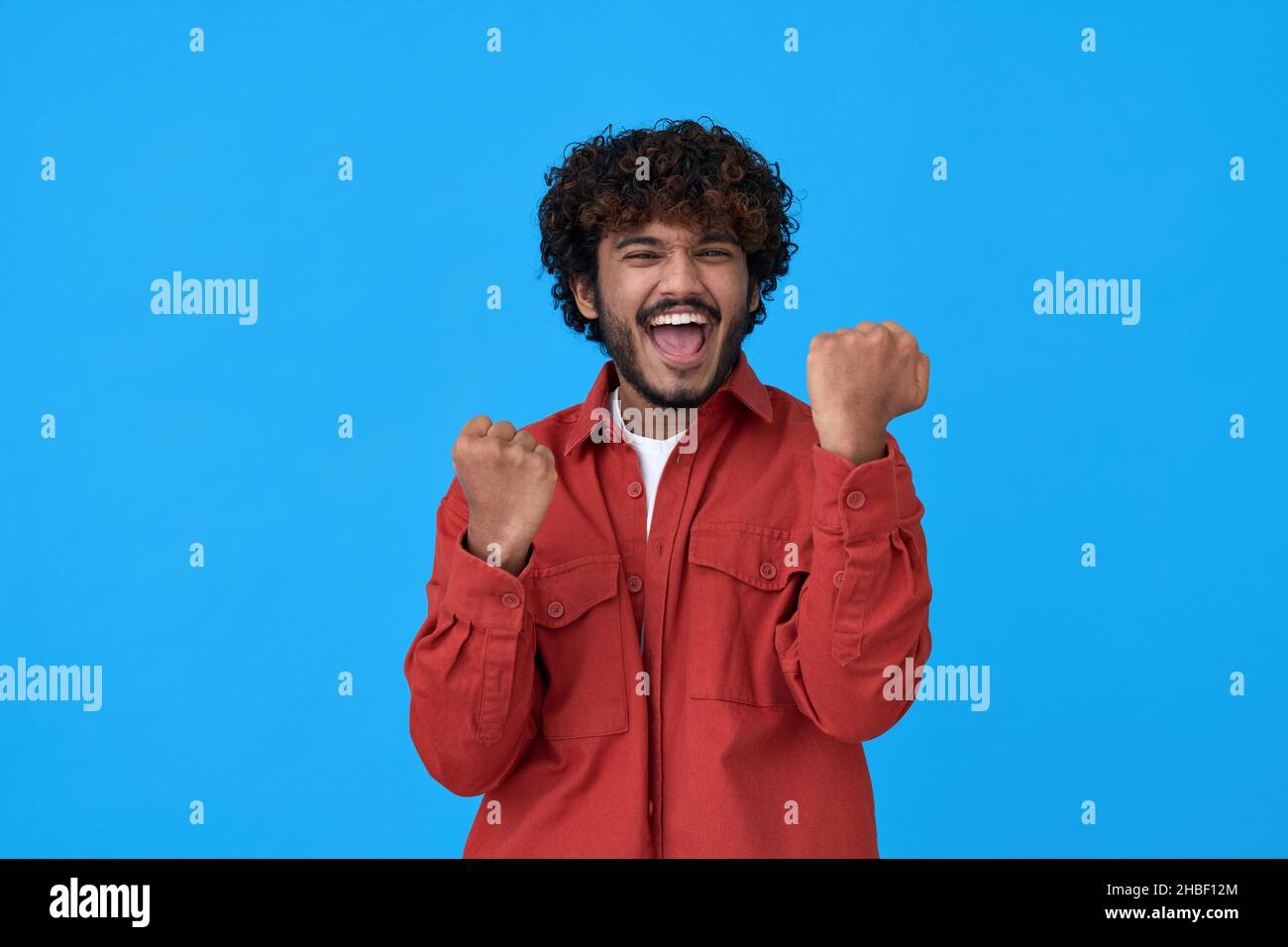 Aufgeregt glücklich jungen indischen Mann Gewinner zeigt ja isoliert auf blauem Hintergrund. Stockfoto