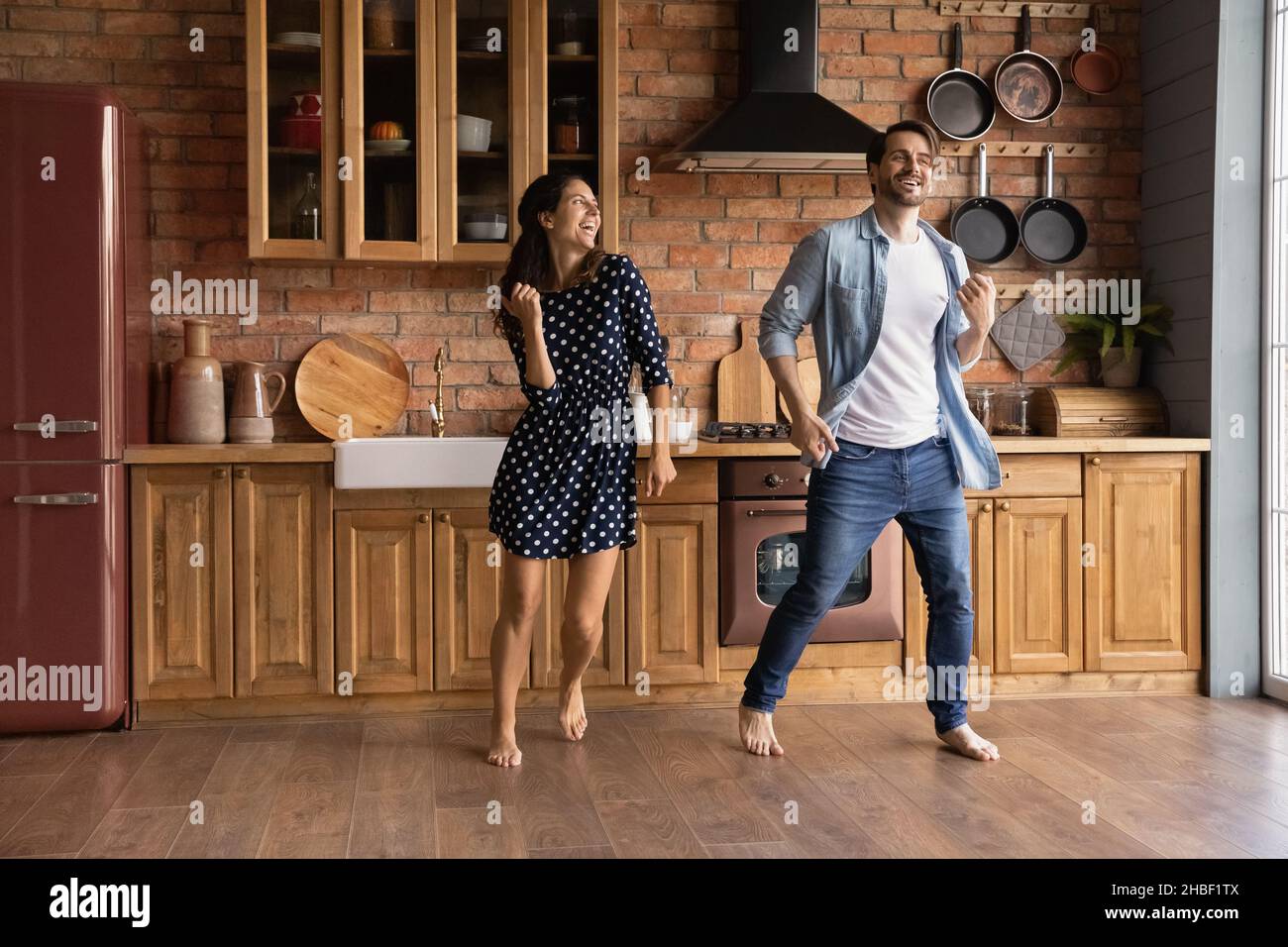 Fröhliches junges Ehepaar, das in der Küche tanzt. Stockfoto