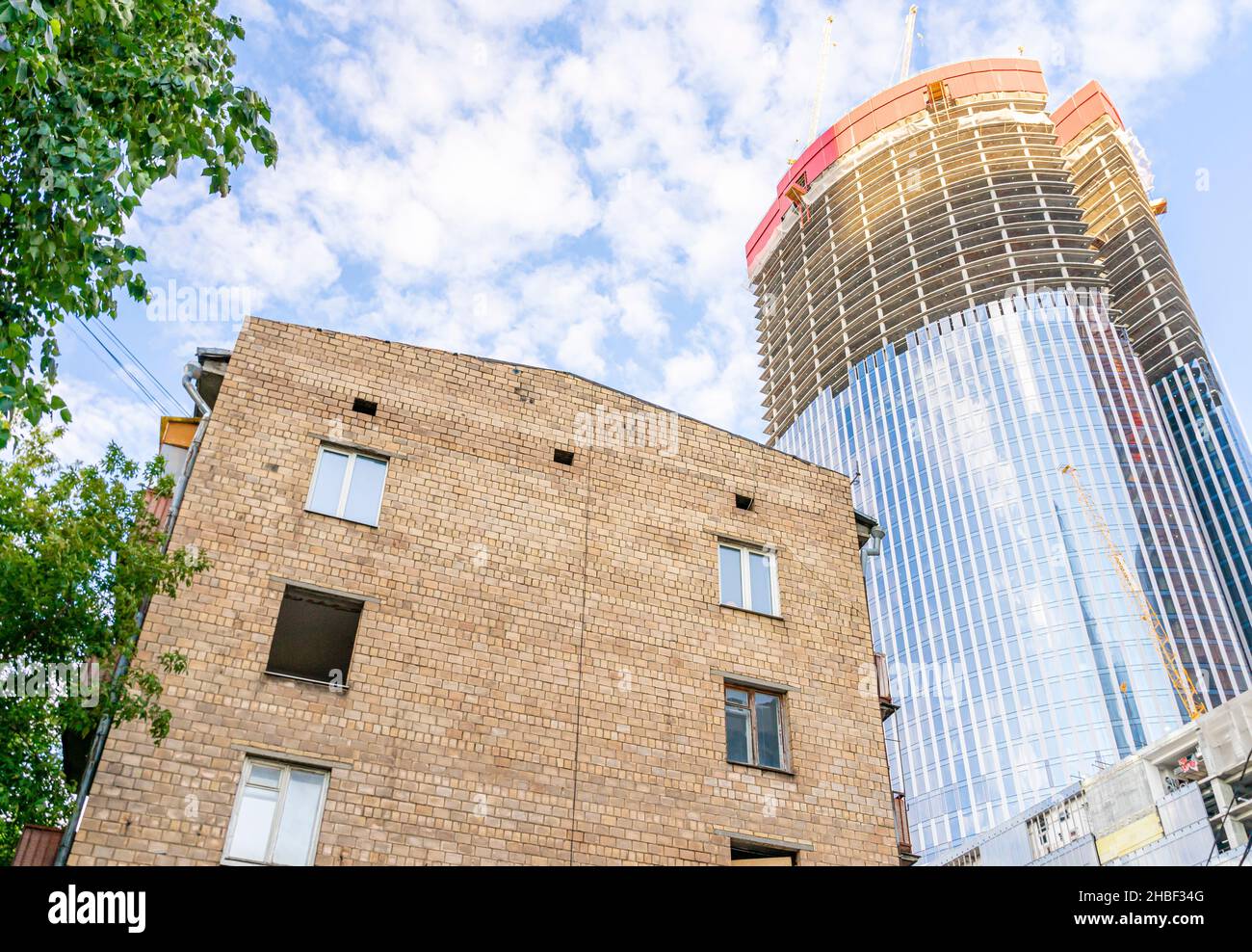 Moskau-Stadt Glastürme skyscrapers.behind alte sowjetische Chruschevka Wohngebäude in Moskau, Russland. Konzept- Stadtentwicklung, Urbanisierung. Stockfoto