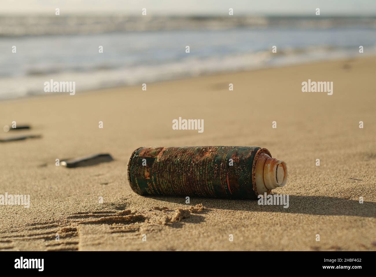 Altes verrosttes Spray kann auf dem Meeresküsten-Ökosystem, Verschmutzung durch die Natur, weggeworfen werden Stockfoto