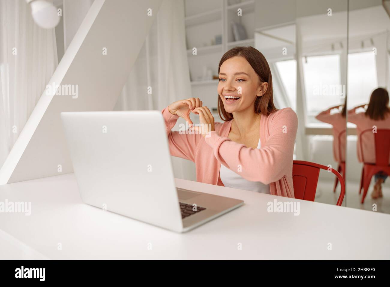 Hübsche Dame mit Laptop während eines Videoanrufs Stockfoto