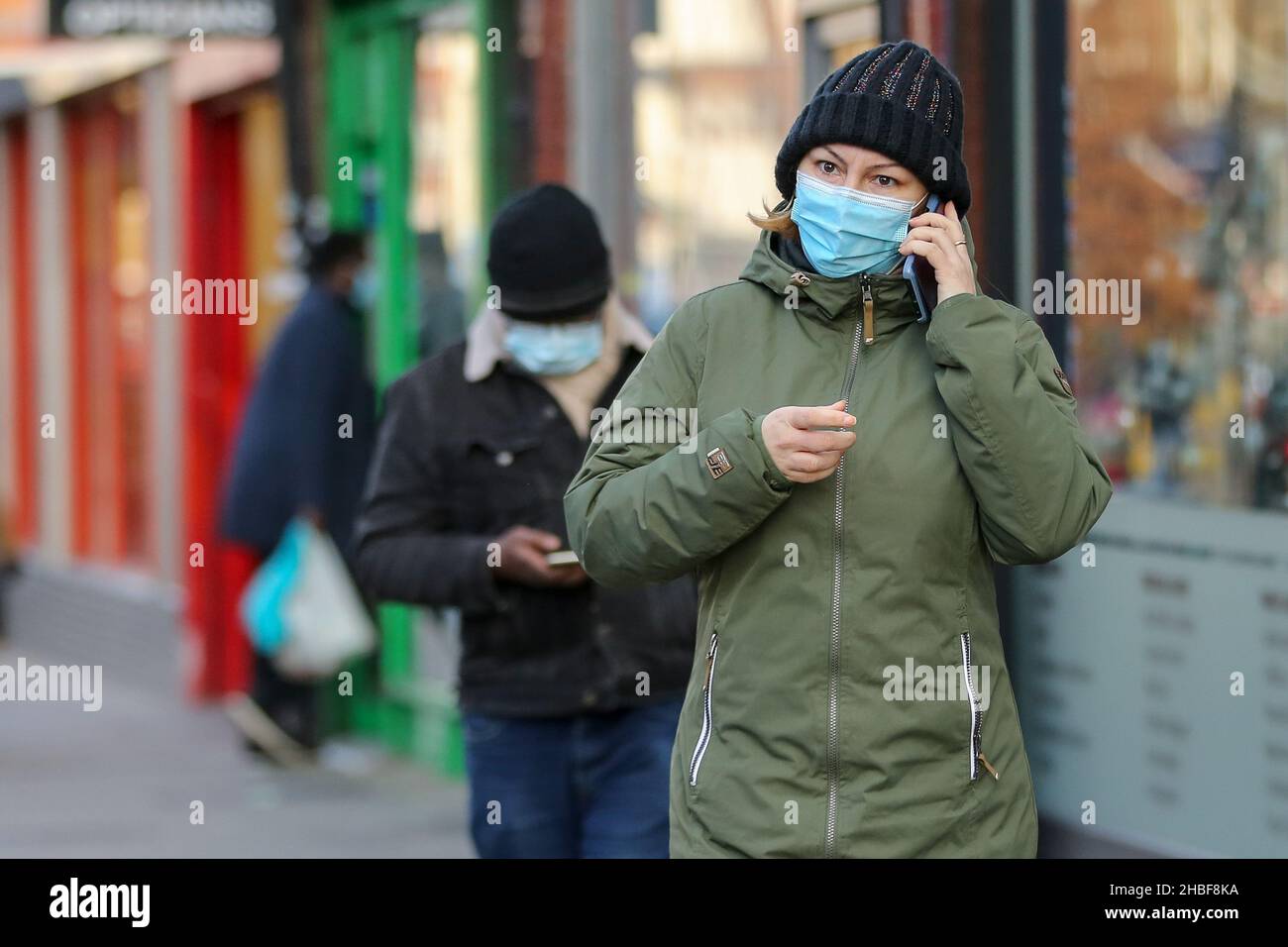 London, Großbritannien. 10th Dez 2021. Eine Frau mit Gesichtsmaske spricht am Telefon, während sie auf der Straße geht. Kredit: SOPA Images Limited/Alamy Live Nachrichten Stockfoto